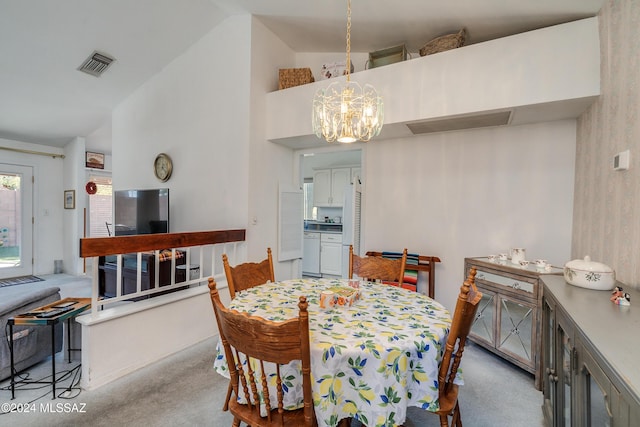 carpeted dining space with high vaulted ceiling and an inviting chandelier