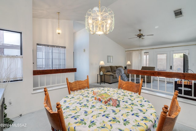 dining area featuring ceiling fan with notable chandelier, a healthy amount of sunlight, lofted ceiling, and french doors