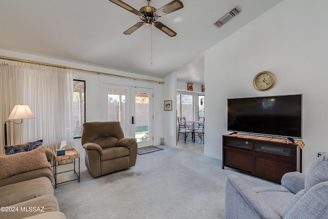 carpeted living room with ceiling fan, vaulted ceiling, and french doors