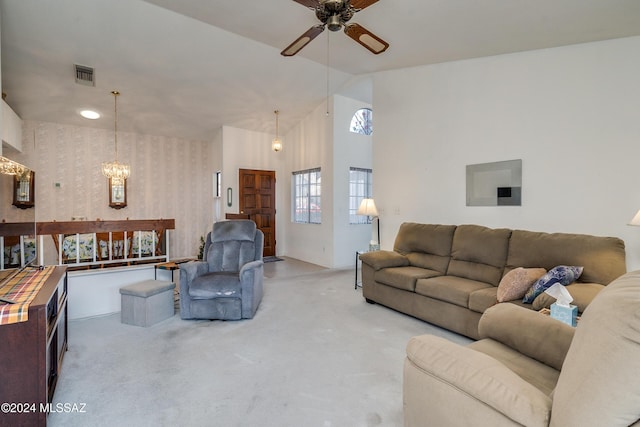 living room with vaulted ceiling, carpet, and ceiling fan with notable chandelier