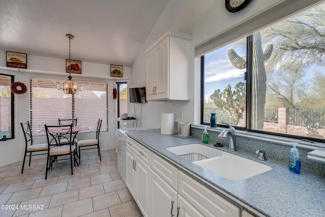 kitchen with white cabinets, sink, light tile patterned floors, decorative light fixtures, and a chandelier