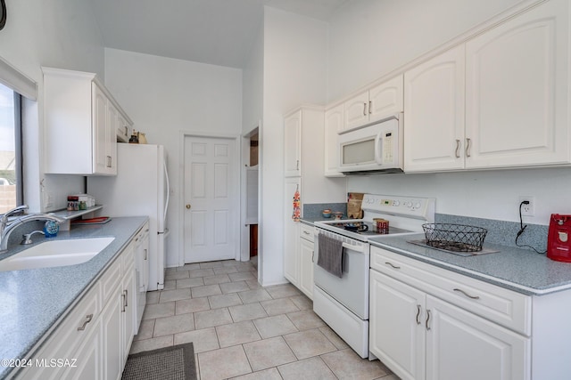 kitchen with white cabinets, white appliances, sink, and light tile patterned floors