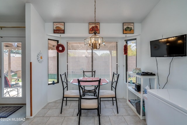 dining room with light tile patterned floors and a notable chandelier