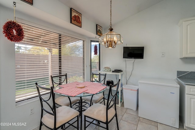 tiled dining room with a notable chandelier and a wealth of natural light