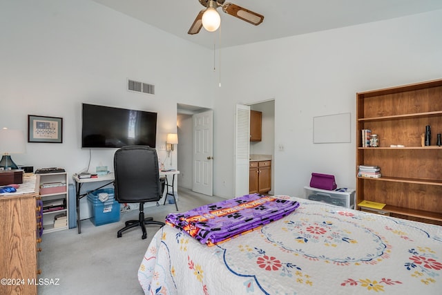 carpeted bedroom featuring ceiling fan and a towering ceiling