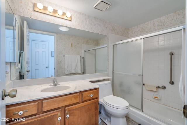 bathroom featuring vanity, toilet, and an enclosed shower