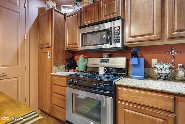 kitchen featuring light stone countertops and appliances with stainless steel finishes