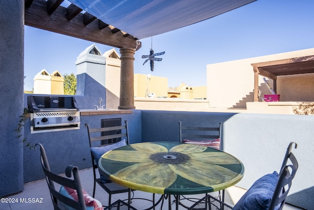 view of patio with sink, a balcony, and a grill