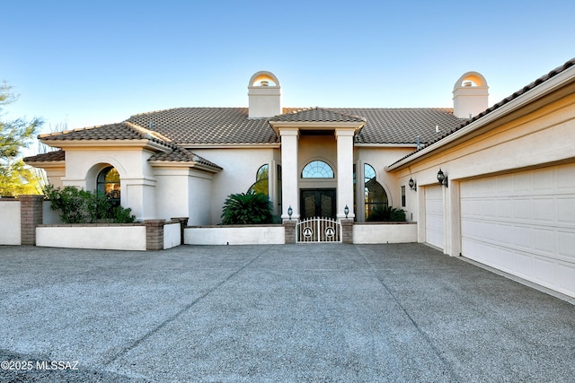 mediterranean / spanish house featuring a garage and french doors