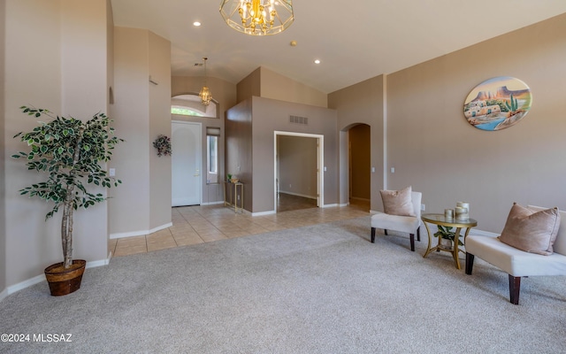 sitting room featuring light colored carpet, high vaulted ceiling, and a notable chandelier