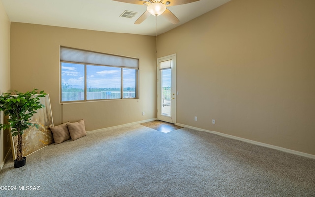 carpeted spare room with ceiling fan and lofted ceiling