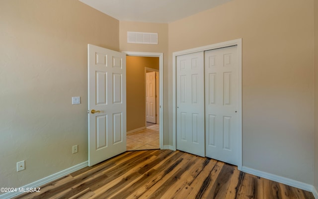 unfurnished bedroom with a closet and wood-type flooring