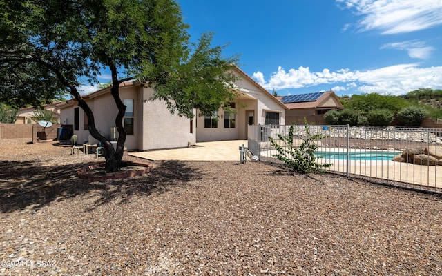 rear view of house with a patio and a fenced in pool