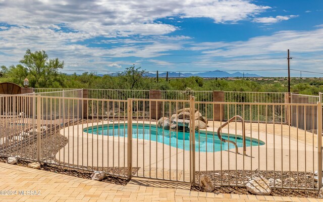 view of swimming pool with a patio area and a mountain view