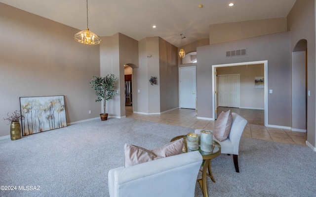 living room featuring light carpet, high vaulted ceiling, and an inviting chandelier