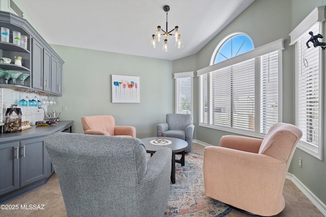 interior space with light tile patterned floors, a dry bar, a notable chandelier, and baseboards