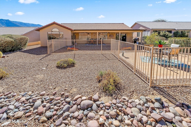 view of front of property with a patio, fence, a pool, and stucco siding