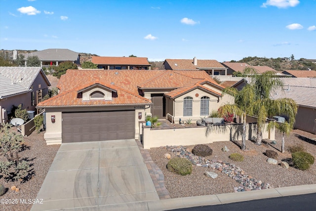 view of front of house featuring an attached garage, a tile roof, concrete driveway, and stucco siding