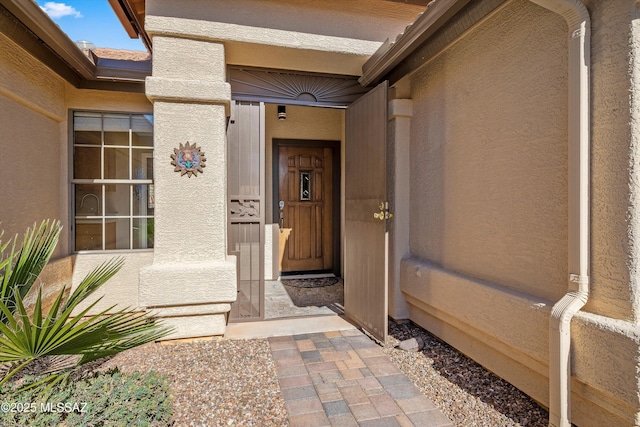 entrance to property featuring stucco siding