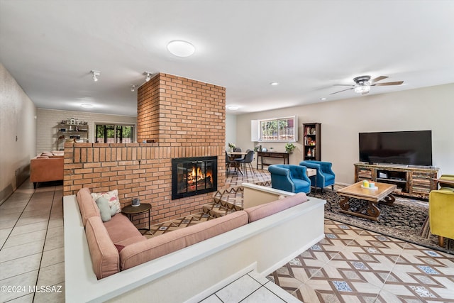 tiled living room with ceiling fan, brick wall, and a brick fireplace