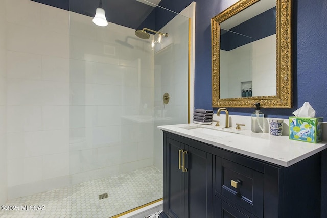 bathroom with a tile shower and vanity