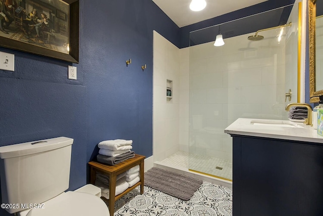 bathroom with tile patterned floors, vanity, toilet, and tiled shower