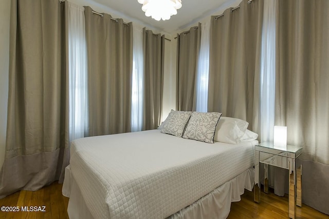 bedroom featuring hardwood / wood-style floors and an inviting chandelier