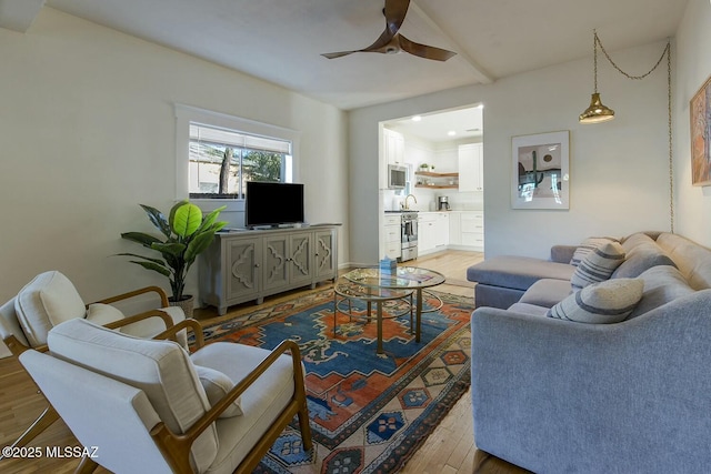 living room featuring hardwood / wood-style floors and ceiling fan