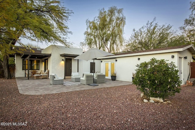 back house at dusk with a patio area and an outdoor hangout area