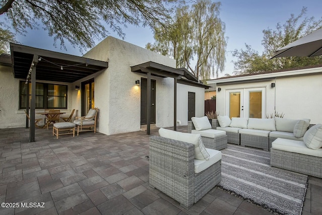 patio terrace at dusk featuring outdoor lounge area and french doors