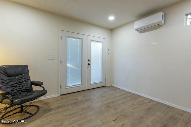 doorway to outside with a wall mounted air conditioner, light wood-type flooring, and french doors