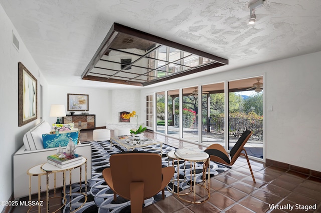 living area featuring baseboards and visible vents