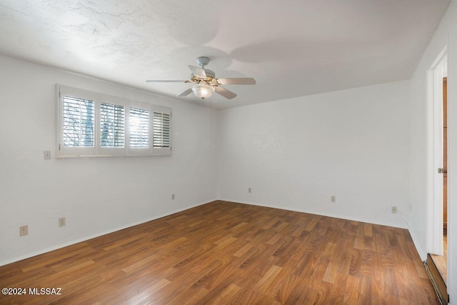 spare room featuring wood-type flooring and ceiling fan