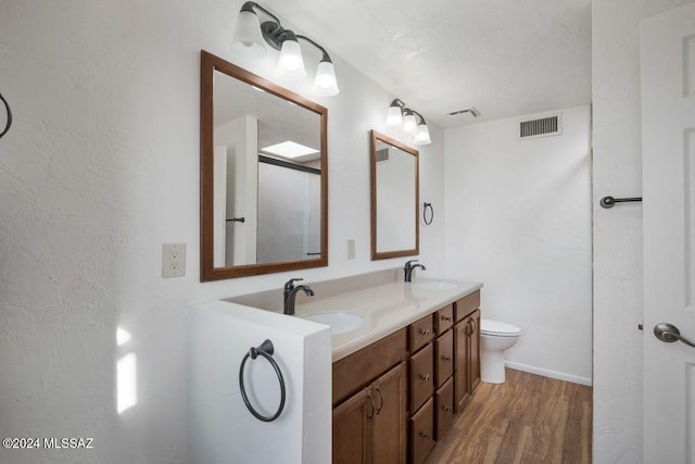full bath featuring wood finished floors, a sink, and visible vents