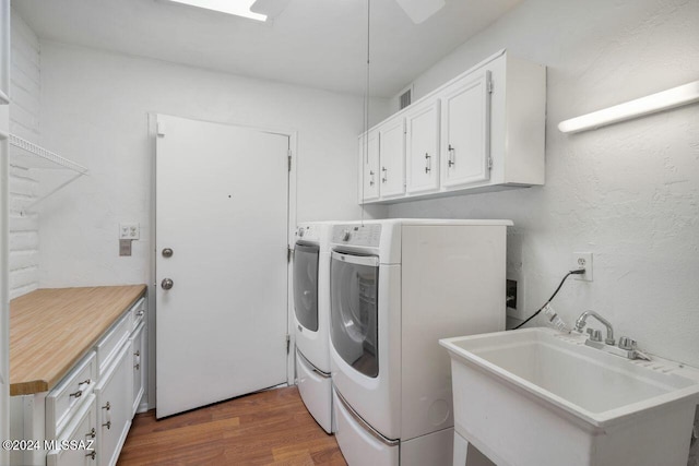 washroom with washer and dryer, dark hardwood / wood-style floors, cabinets, and sink