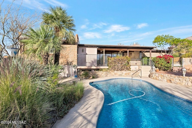 view of pool with a fenced in pool, fence, and ceiling fan