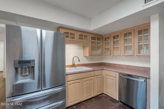 kitchen featuring appliances with stainless steel finishes, light brown cabinetry, and sink