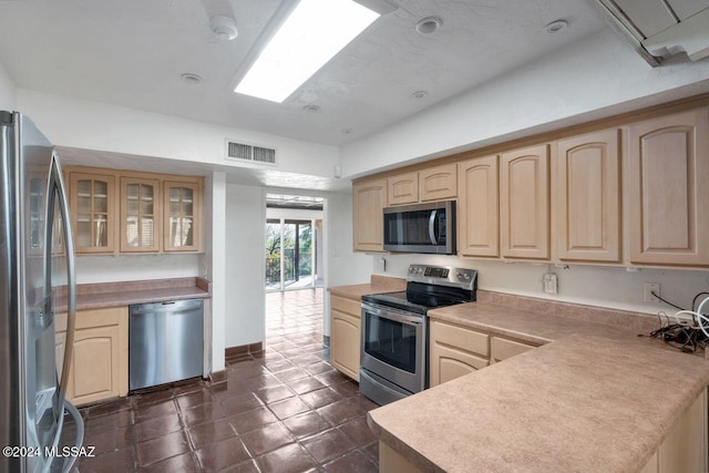 kitchen with light brown cabinetry and appliances with stainless steel finishes