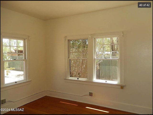 unfurnished room with dark hardwood / wood-style floors and plenty of natural light