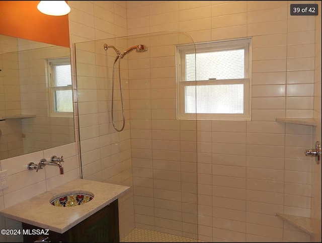 bathroom featuring a tile shower and sink