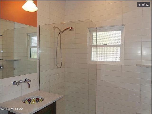 bathroom featuring tiled shower and sink