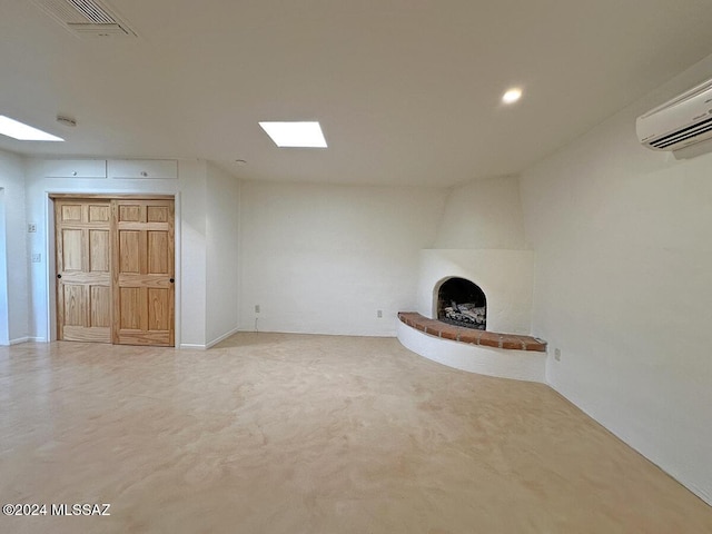 unfurnished living room with a wall unit AC, carpet flooring, and a fireplace