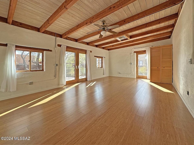 unfurnished living room with ceiling fan, french doors, beamed ceiling, and wooden ceiling