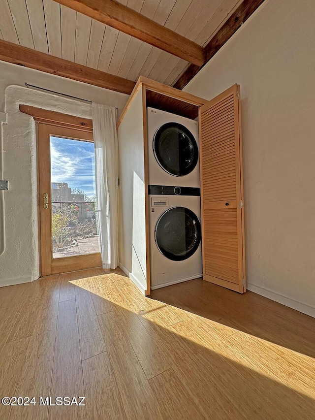 laundry room featuring wood-type flooring, stacked washer and dryer, and wood ceiling