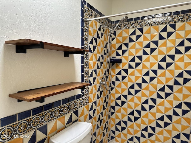 bathroom featuring tiled shower and toilet