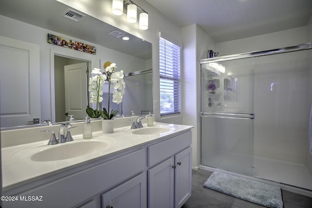 bathroom featuring tile patterned floors, vanity, and a shower with shower door