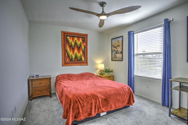 bedroom featuring ceiling fan, light colored carpet, and multiple windows