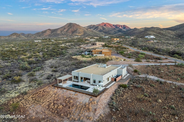 aerial view at dusk featuring a mountain view