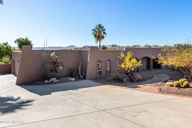 pueblo-style home featuring a garage