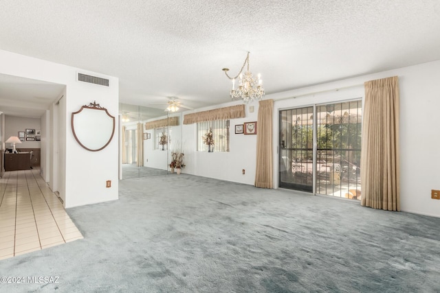 unfurnished living room featuring carpet, ceiling fan with notable chandelier, and a textured ceiling